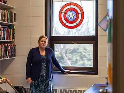 政治学副教授安妮卡·哈格利(Annika Hagley)站在美国队长彩色玻璃罩下的办公室里.